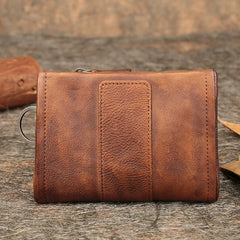 Brown leather biker bifold wallet with key ring on rustic wood