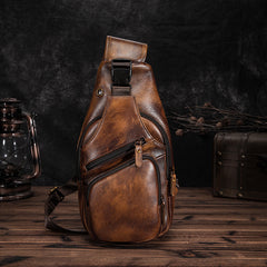 Vintage brown leather sling chest bag on dark wood