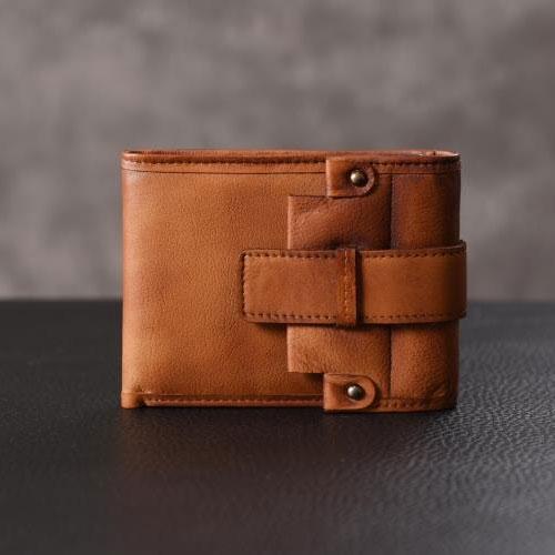 Brown leather slim wallet closed with double straps, studio shot