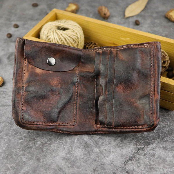 Open vintage distressed leather billfold wallet with snap coin pocket and card slots, dark brown