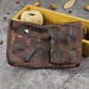 Open vintage distressed leather billfold wallet with snap coin pocket and card slots, dark brown