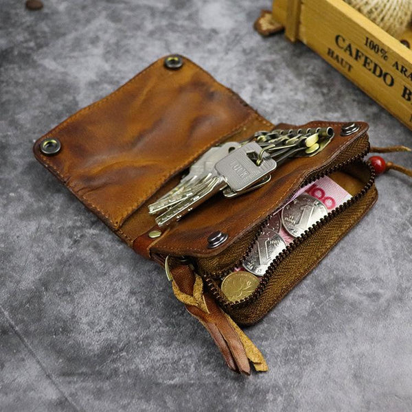Open vintage brown leather key wallet showing keys on holders and zip coin pocket