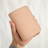 Hand holding natural beige vegetable tanned leather billfold biker wallet with white stitching