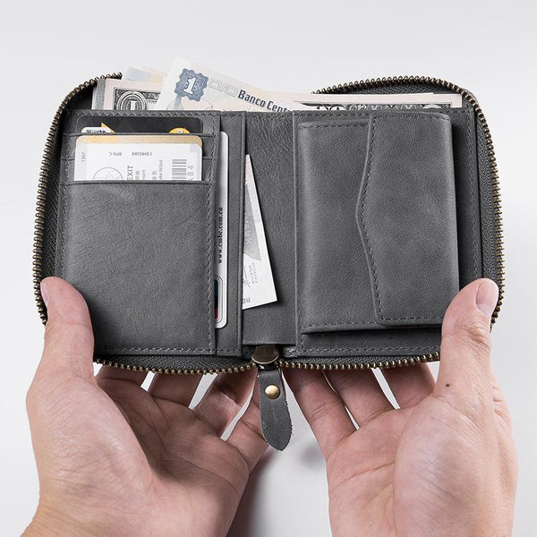 Open gray leather zip-around billfold wallet with card slots, bill slot and change pocket, held in hands